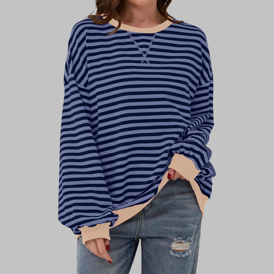 Woman wearing blue and navy striped sweatshirt with tan contrast trim