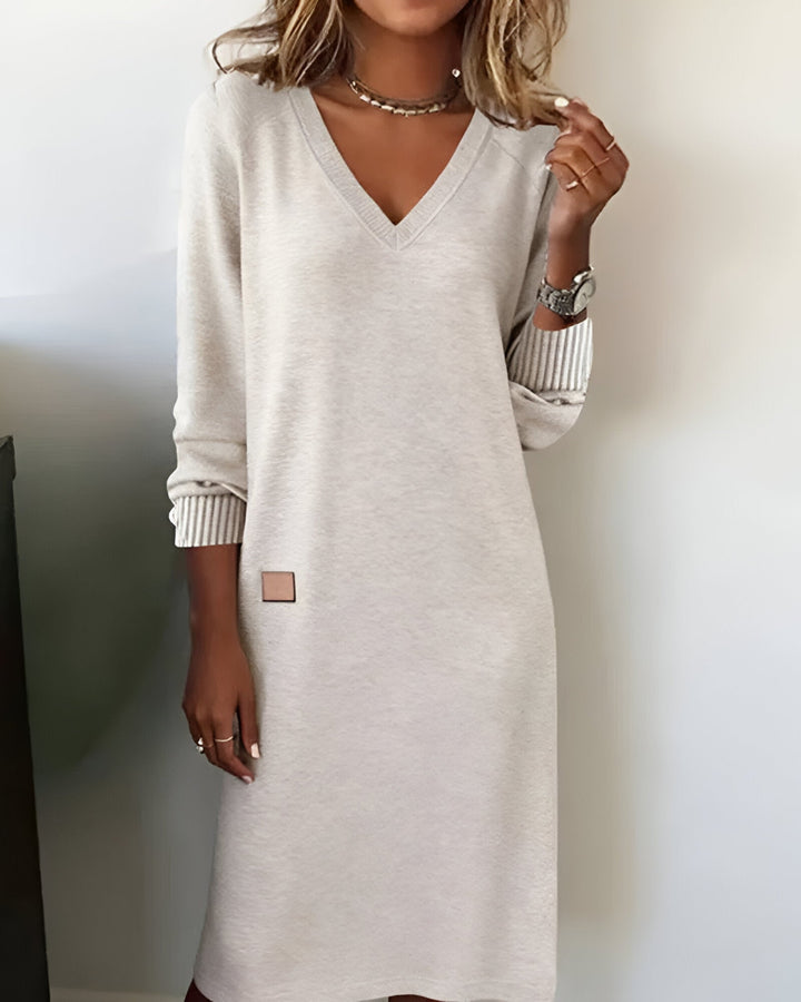 Woman wearing white V-neck midi dress with ribbed cuffs