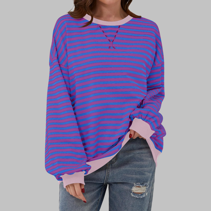 Woman wearing purple and blue striped sweatshirt with pink contrast trim
