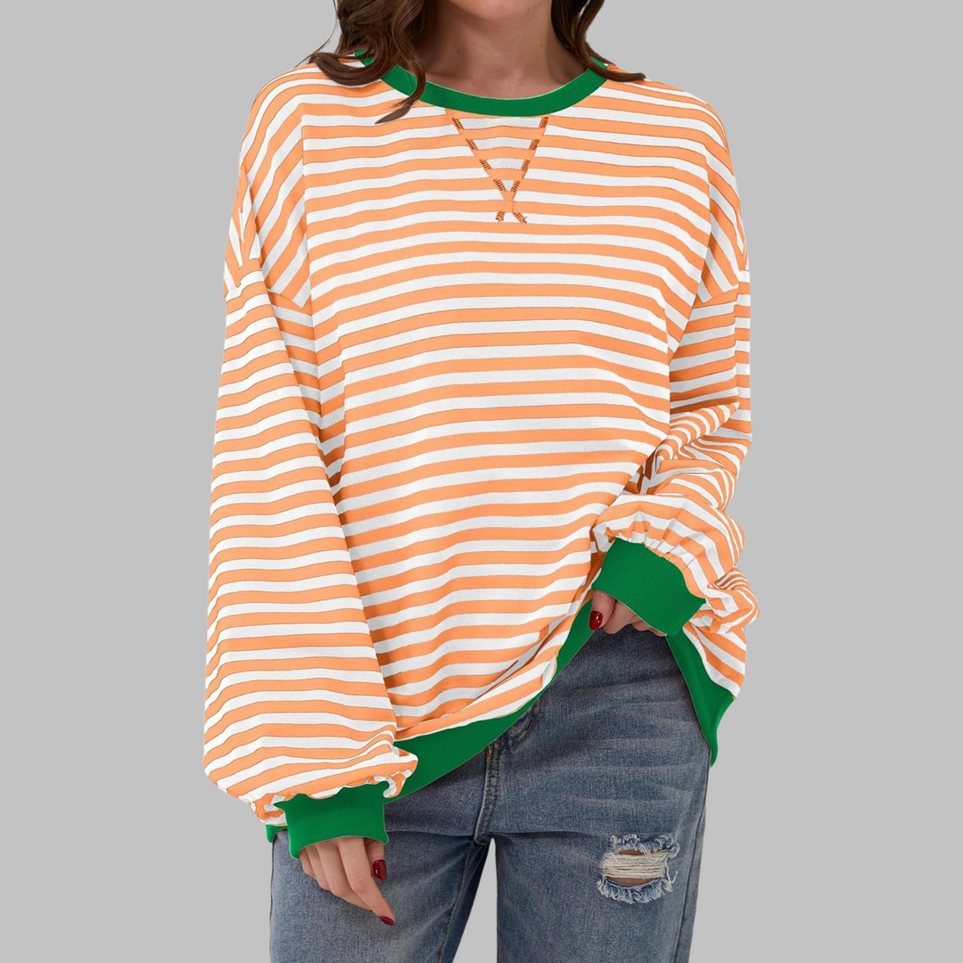 Woman wearing orange and white striped sweatshirt with green contrast trim
