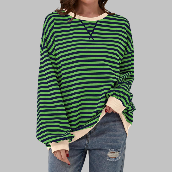 Woman wearing green and navy striped sweatshirt with contrast cream trim