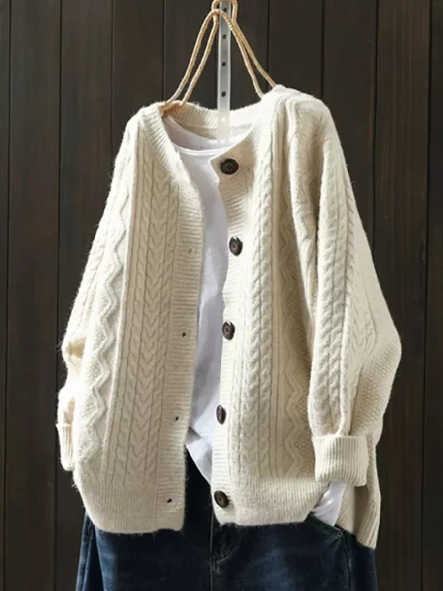Beige cable knit button front cardigan on hanger