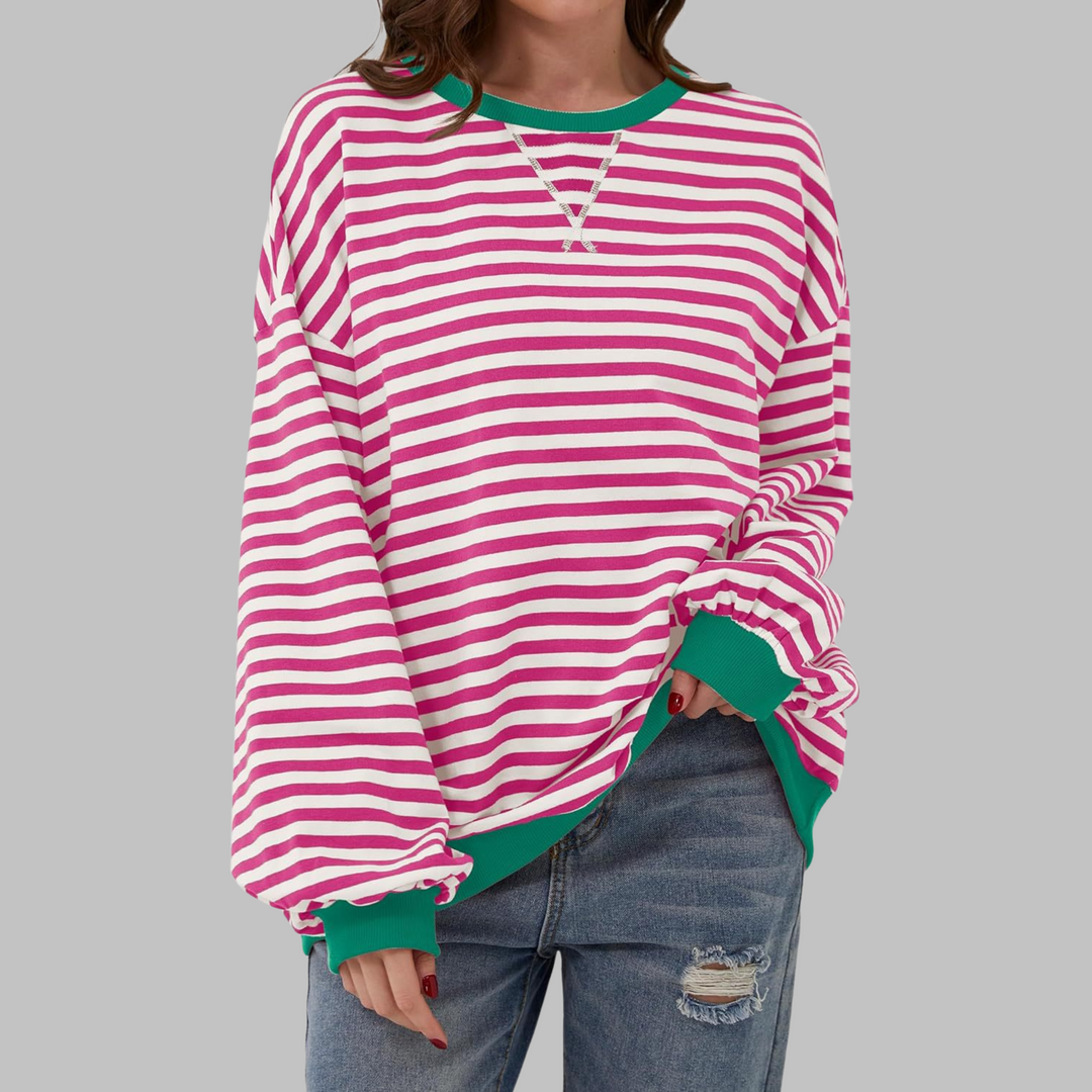 Woman wearing pink and white striped sweatshirt with green contrast trim