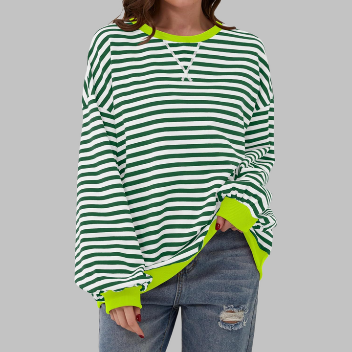 Woman wearing dark green and white striped sweatshirt with neon trim