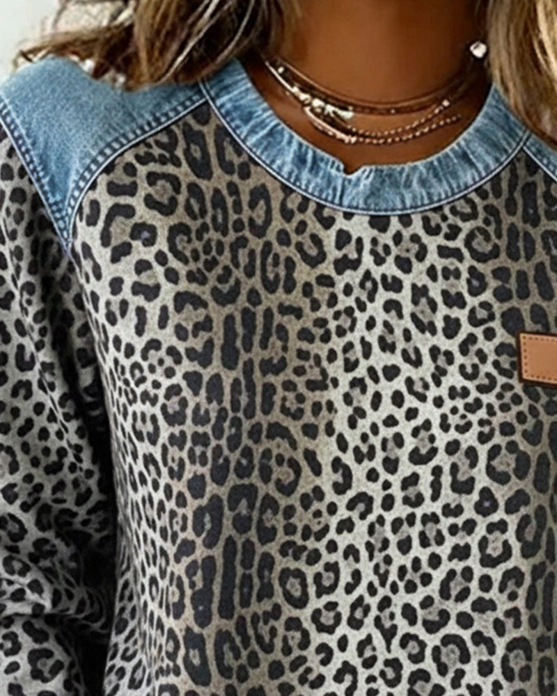 Close up of gray leopard print sweatshirt crew neckline and denim yoke