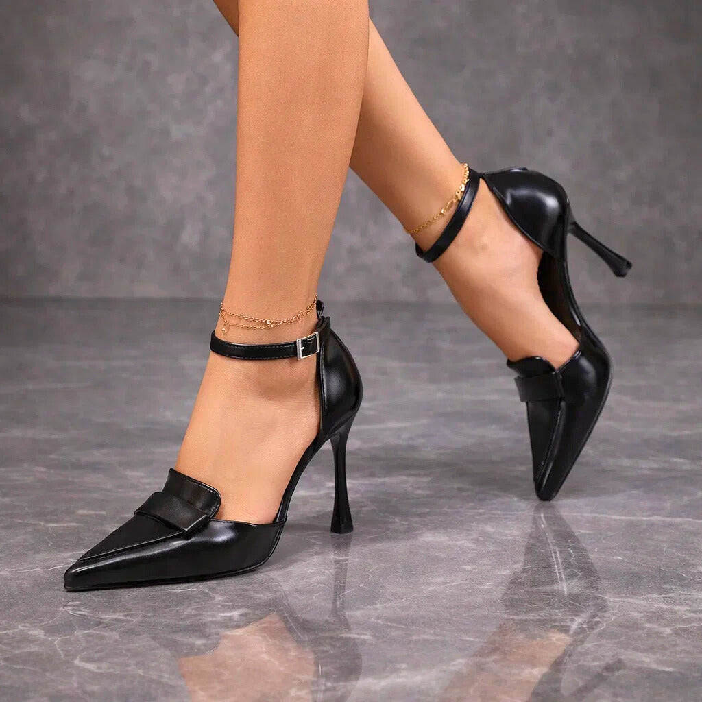 Black pointed-toe pumps with ankle strap shown mid-stride