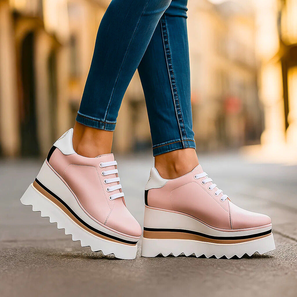 Pink tiered platform sneakers with white accents, side view on model