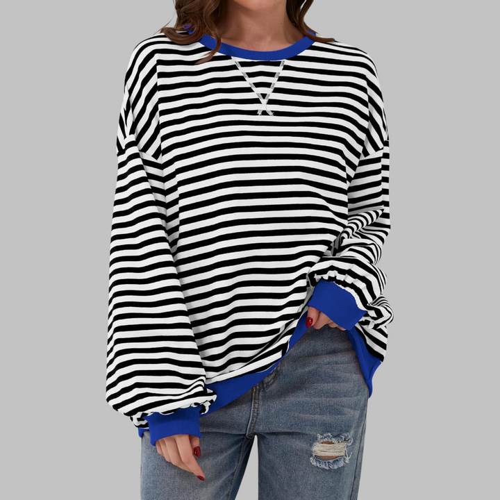 Woman wearing black and white striped sweatshirt with blue contrast trim