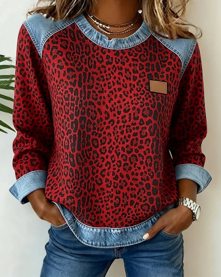 Woman wearing red leopard print sweatshirt with denim colorblock raglan sleeves
