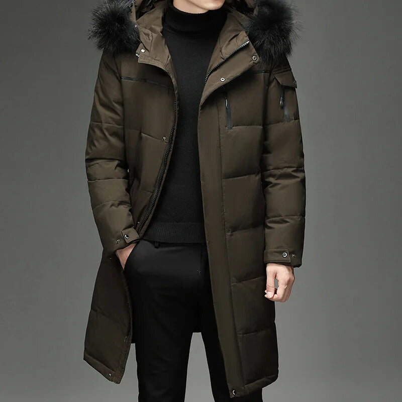 Man wearing army green hooded down coat with fur trim, hand in pocket