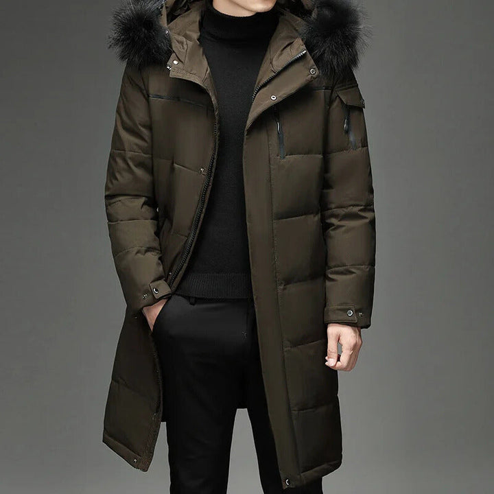 Man wearing army green hooded down coat with fur trim, hand in pocket