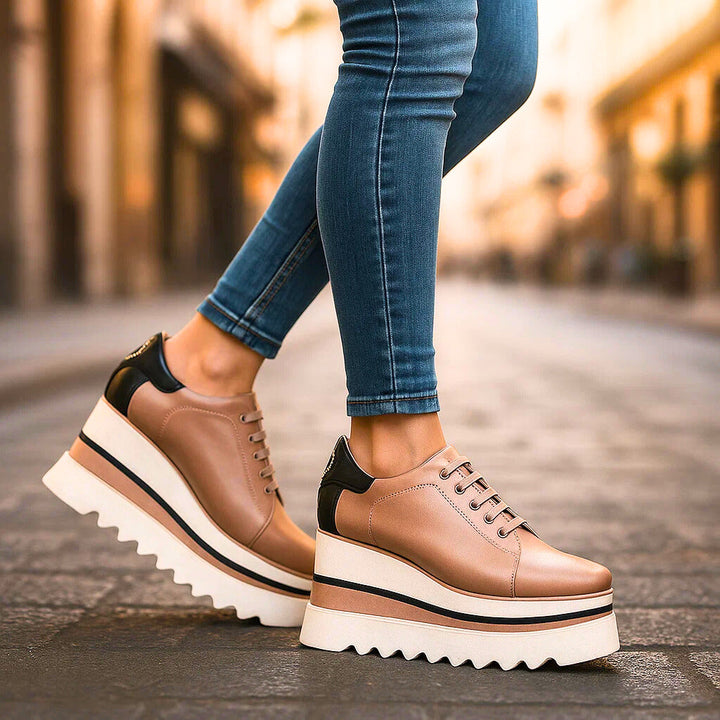 Tan tiered platform sneakers with black heel trim, side profile