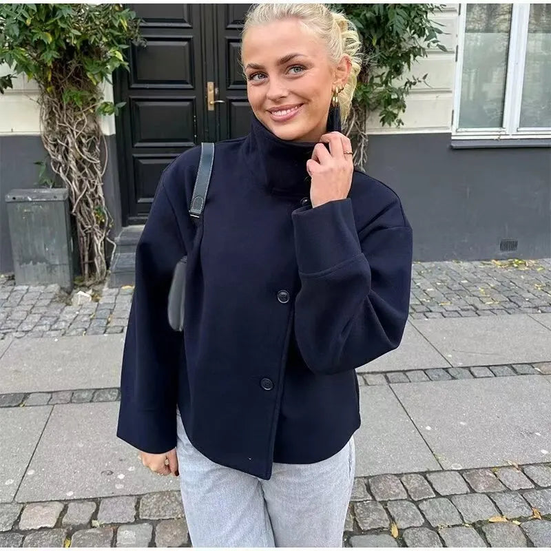 Woman wearing navy blue oversized funnel neck wool jacket on street
