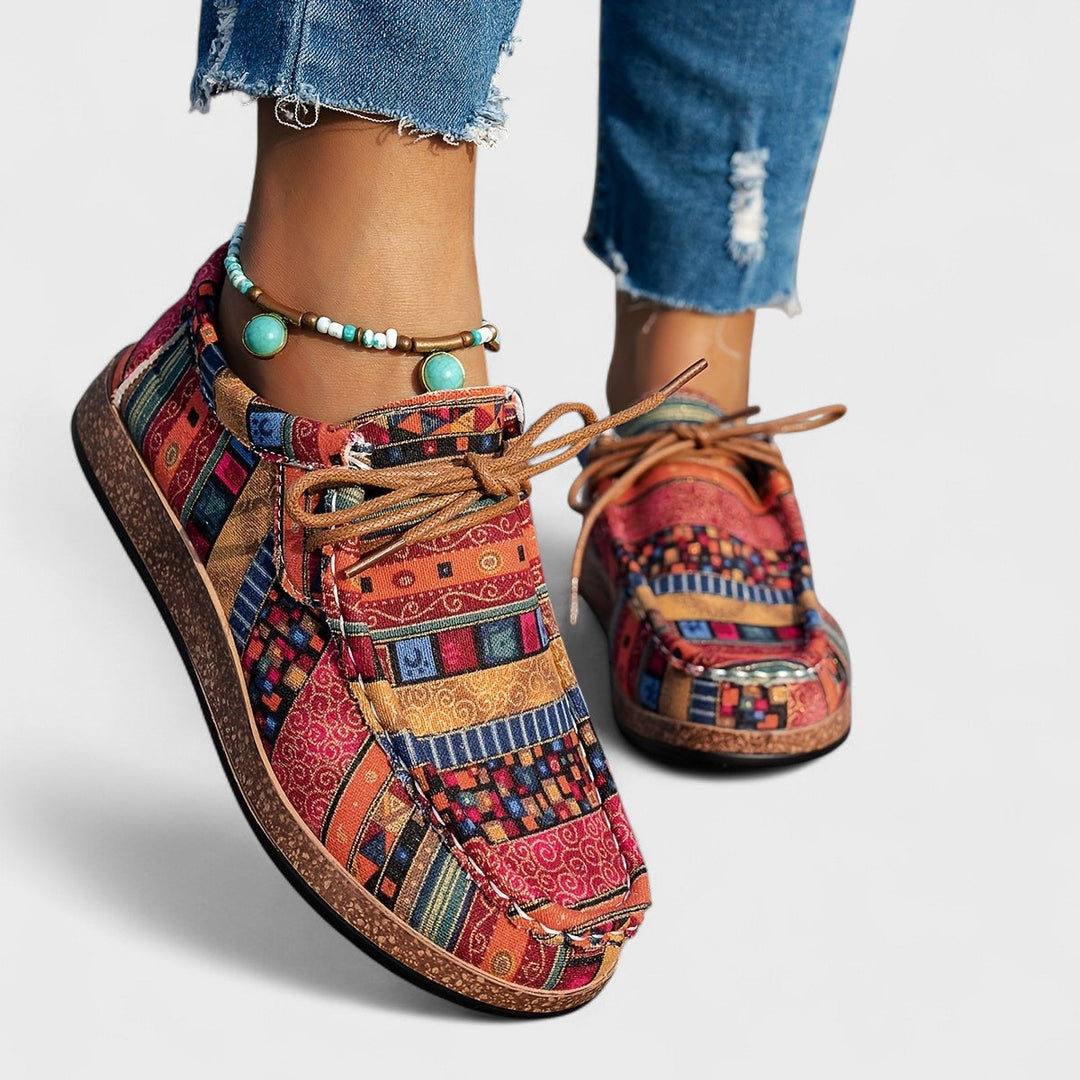 Close-up front view of red multicolor patchwork print lace-up sneakers on model