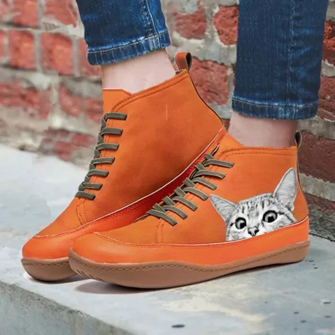 Orange high top boots worn on feet near brick wall