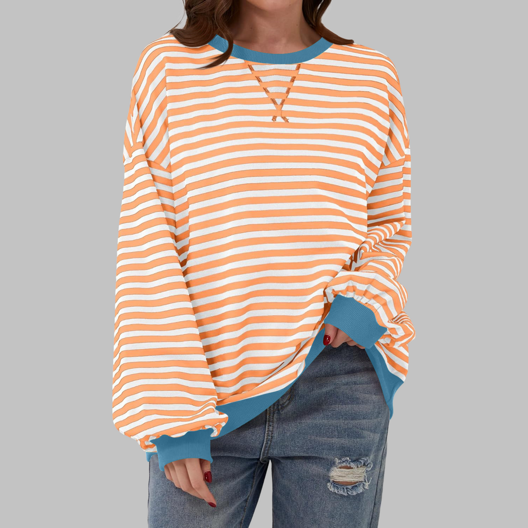 Woman wearing orange and white striped sweatshirt with blue contrast trim