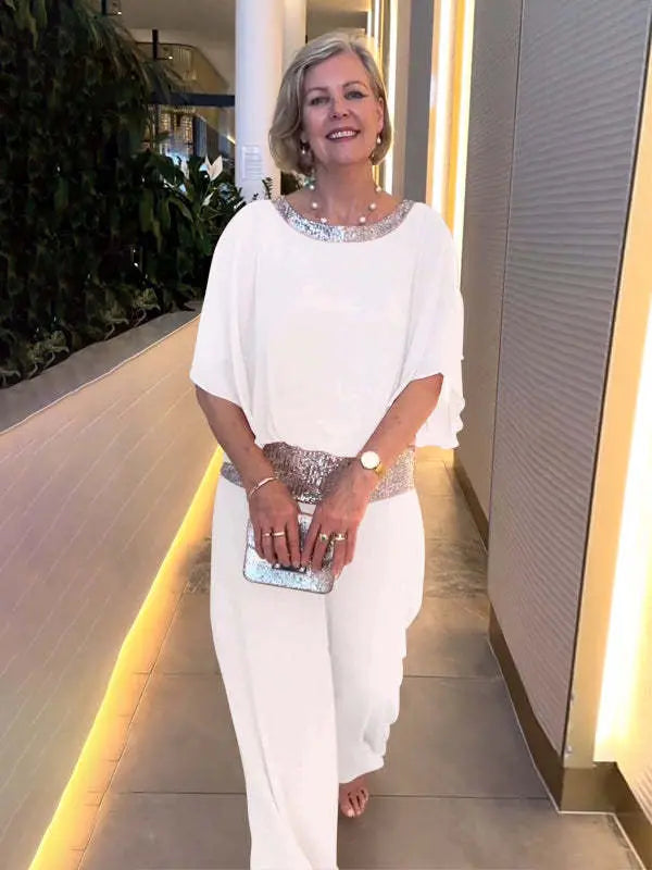 Woman wearing white wide-sleeve top and wide-leg pants set with sequin trim