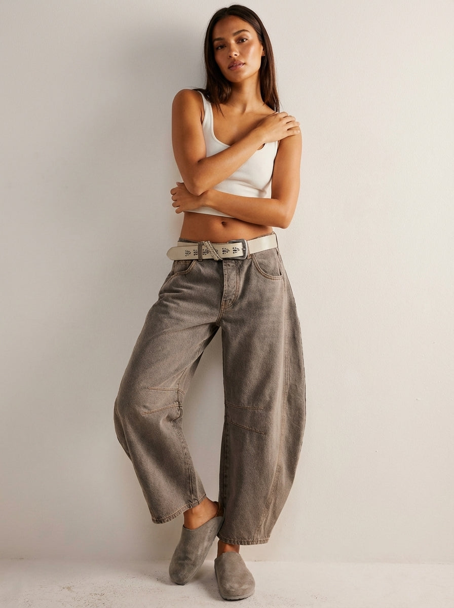 Model wearing brown barrel leg jeans with belt