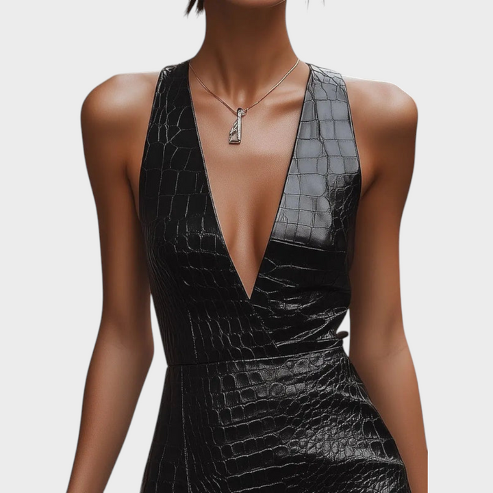 Close-up of deep V-neckline and wrap bodice on black croc-embossed mini dress