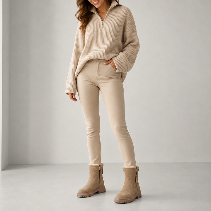 Beige ankle boots styled with beige skinny pants and quarter zip sweater
