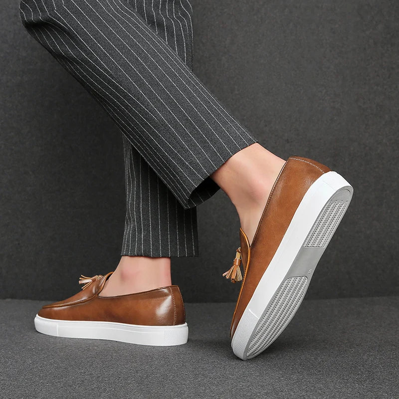 Man modeling brown tasseled loafers, heel lifted view