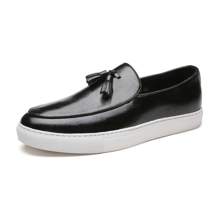 Black tasseled leather loafer on white background