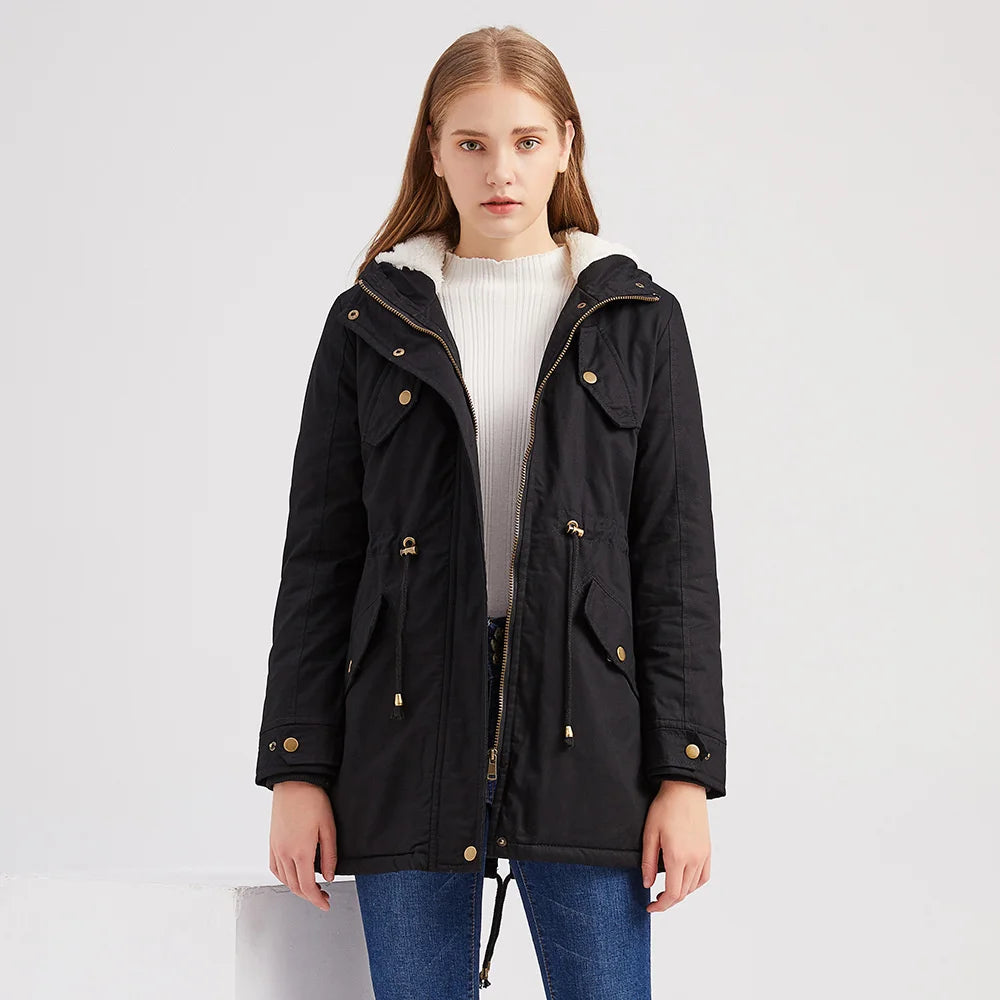 Model wearing black hooded parka coat open over white sweater