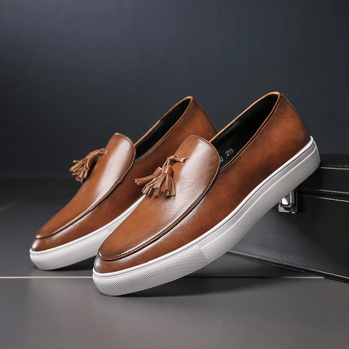 Pair of brown tasseled leather loafers angled view