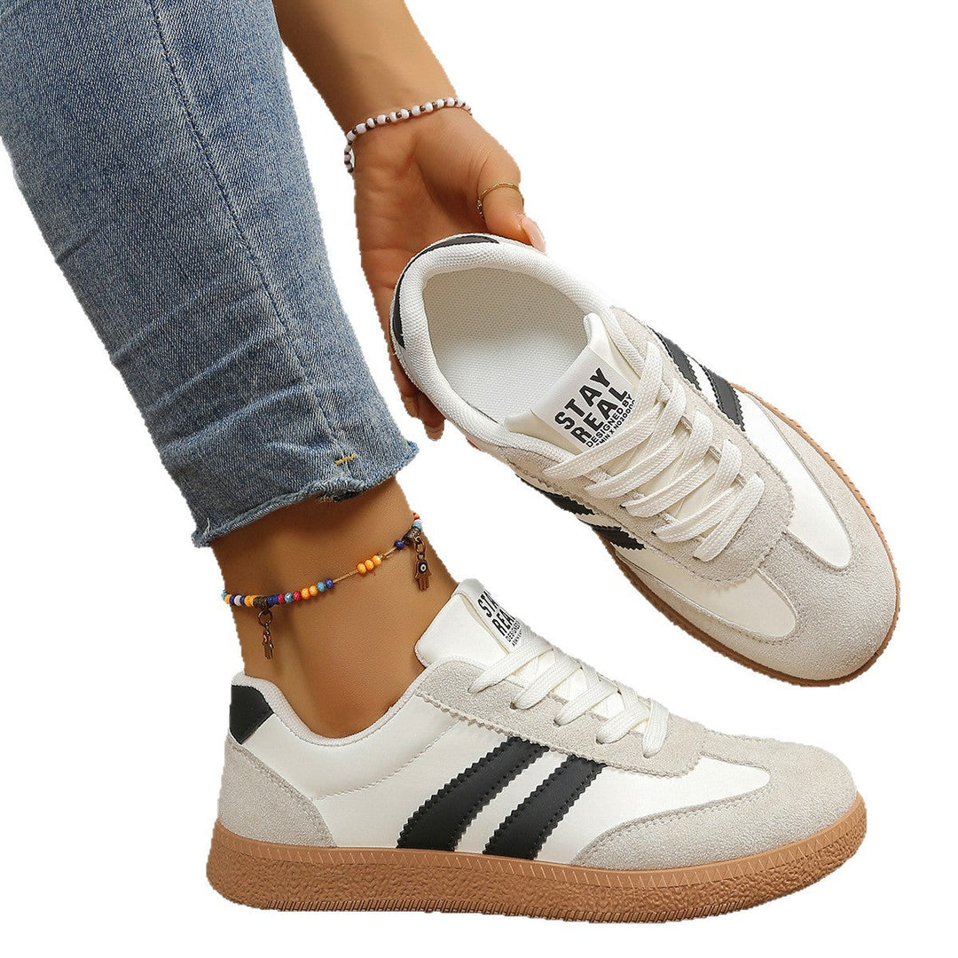 White and black sneaker held by hand showing interior and sole detail