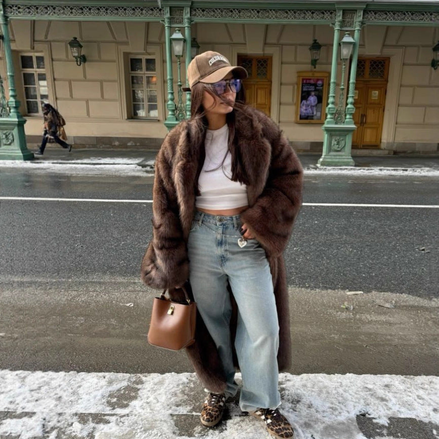 Woman wearing dark brown faux fur longline coat over jeans and white top