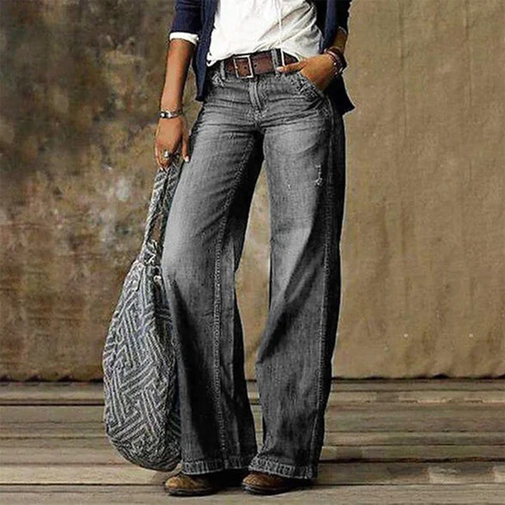 Woman wearing light gray wide leg vintage wash jeans with belt