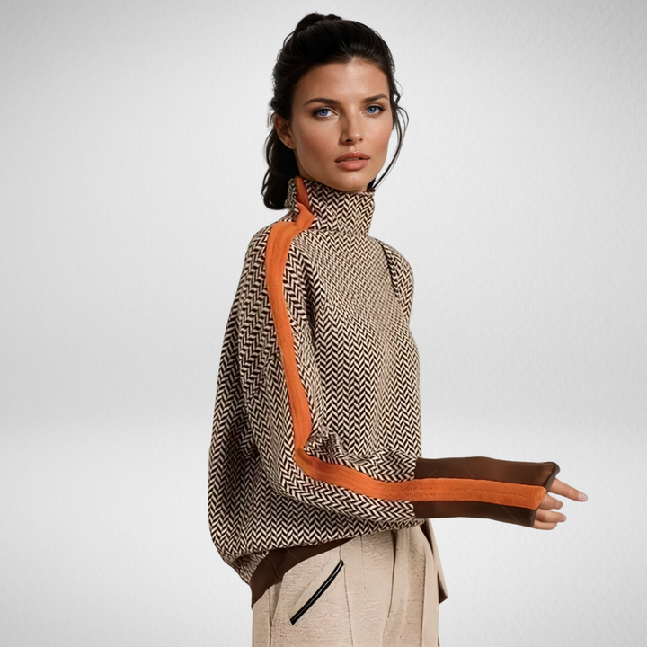 Woman wearing herringbone knit turtleneck sweater with orange raglan stripe and contrast cuffs