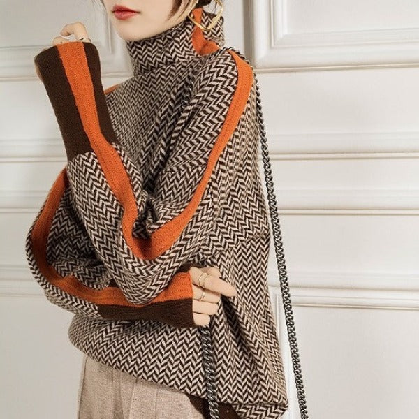 Side view of herringbone knit turtleneck sweater with orange contrast stripe trim
