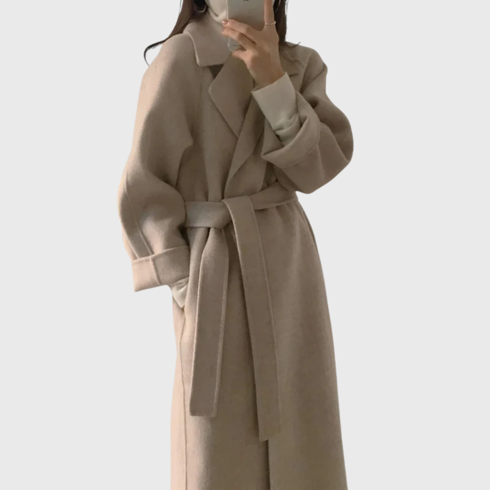 Model wearing beige belted longline coat with raglan sleeves
