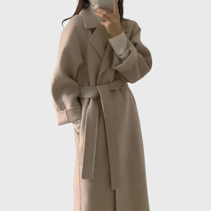 Model wearing beige belted longline coat with raglan sleeves