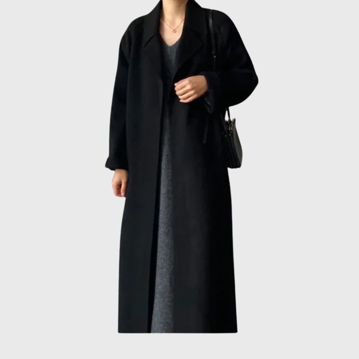 Model wearing black belted longline coat with notched lapels