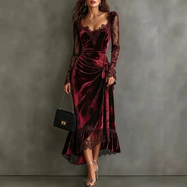 Woman wearing dark red velvet maxi dress with lace sweetheart neckline and tie waist, front view