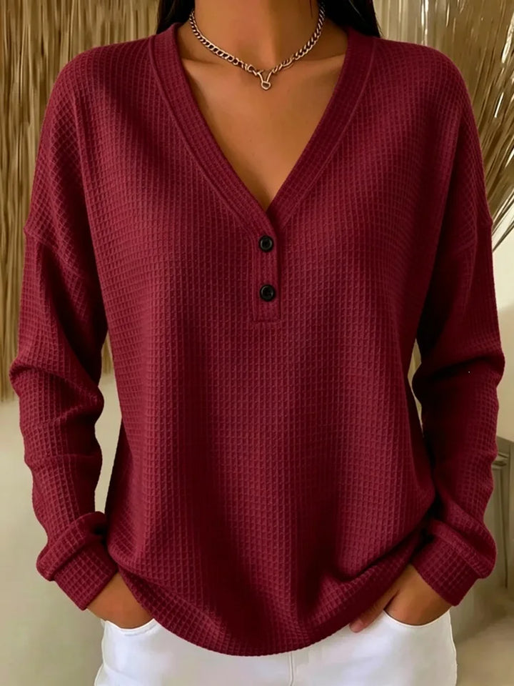 Woman wearing burgundy waffle knit V-neck henley top with button placket