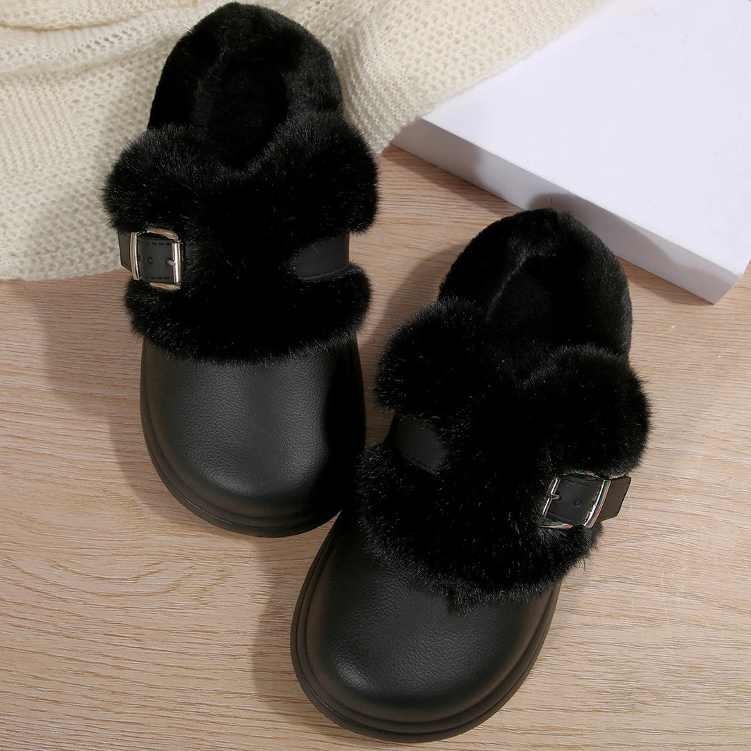Pair of black faux fur platform clog slippers on wood floor