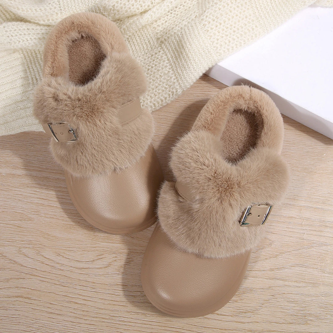 Pair of khaki faux fur platform clog slippers on wood floor