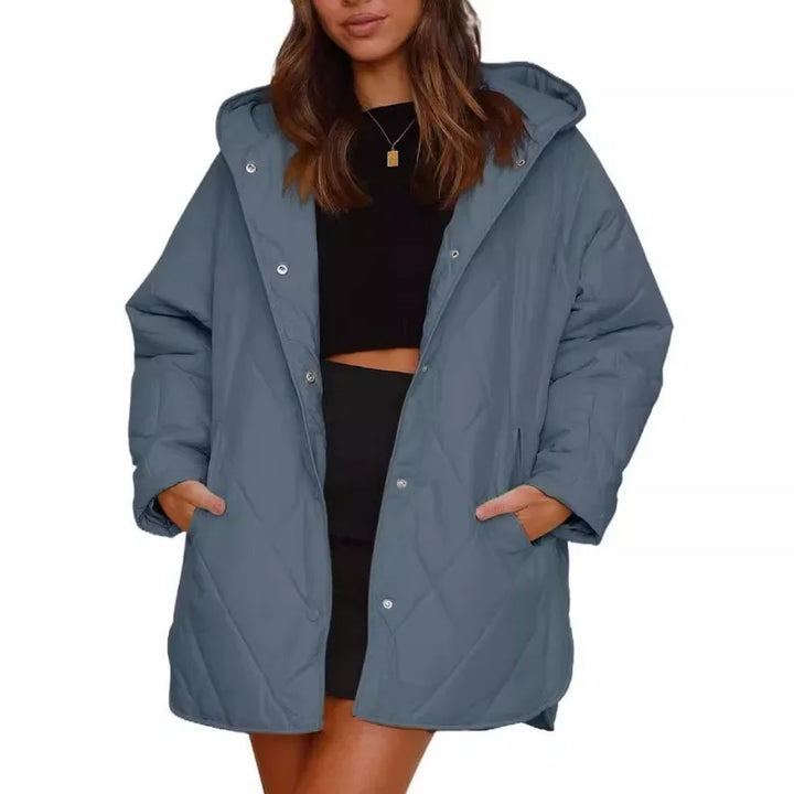 Woman wearing blue diamond quilted hooded jacket with hands in pockets