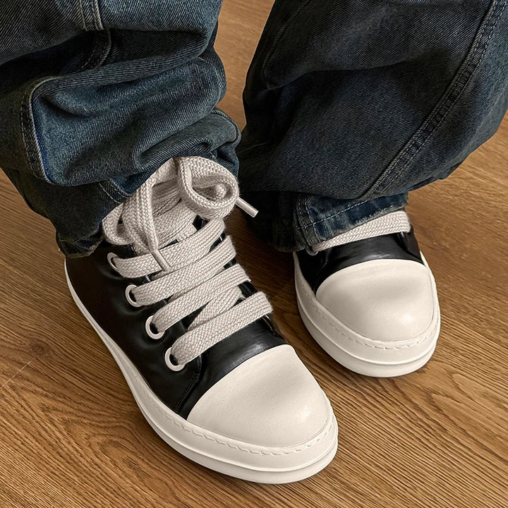 Front view of black and white high top sneakers worn with jeans