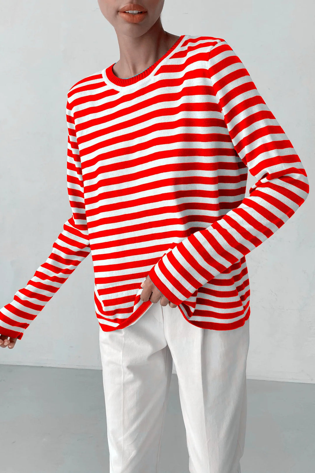 Woman wearing orange red and white striped knit sweater