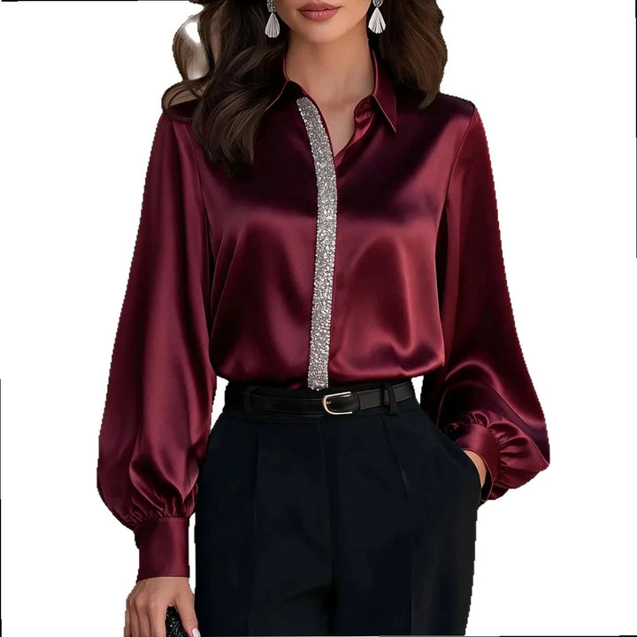 Woman wearing burgundy satin blouse with sparkling trim detail