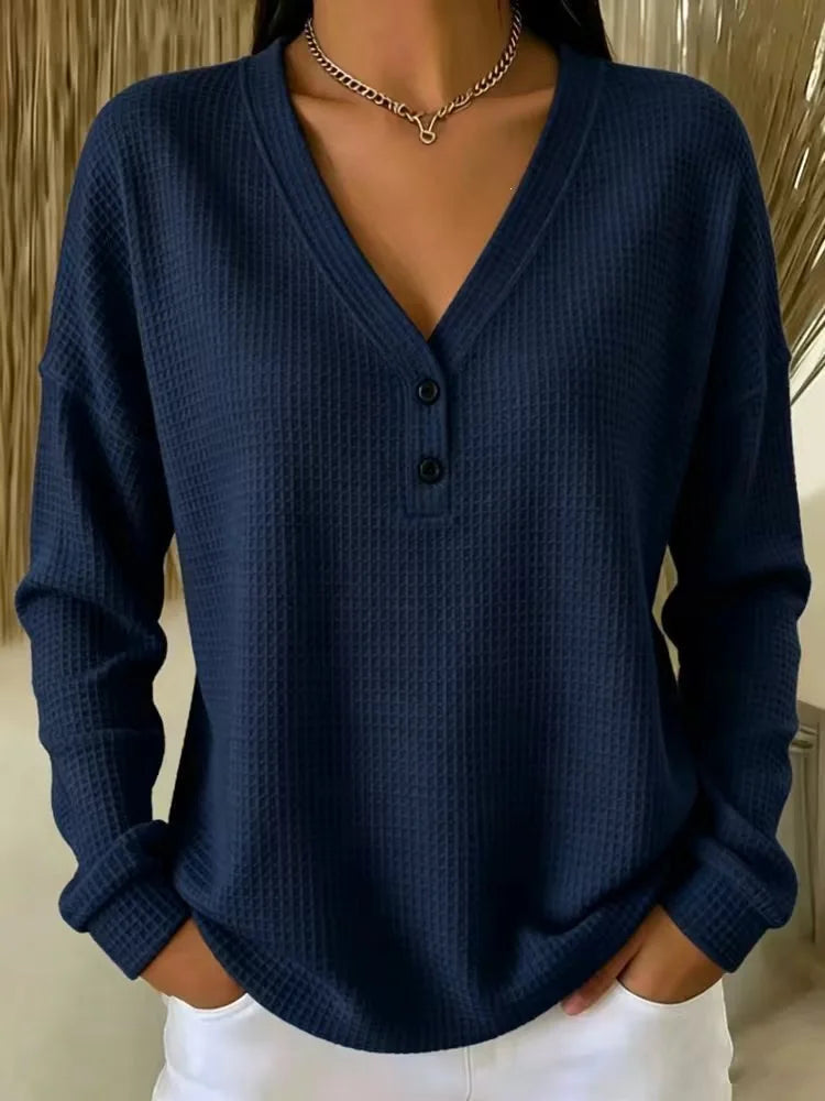 Woman wearing navy blue waffle knit V-neck henley top with button placket