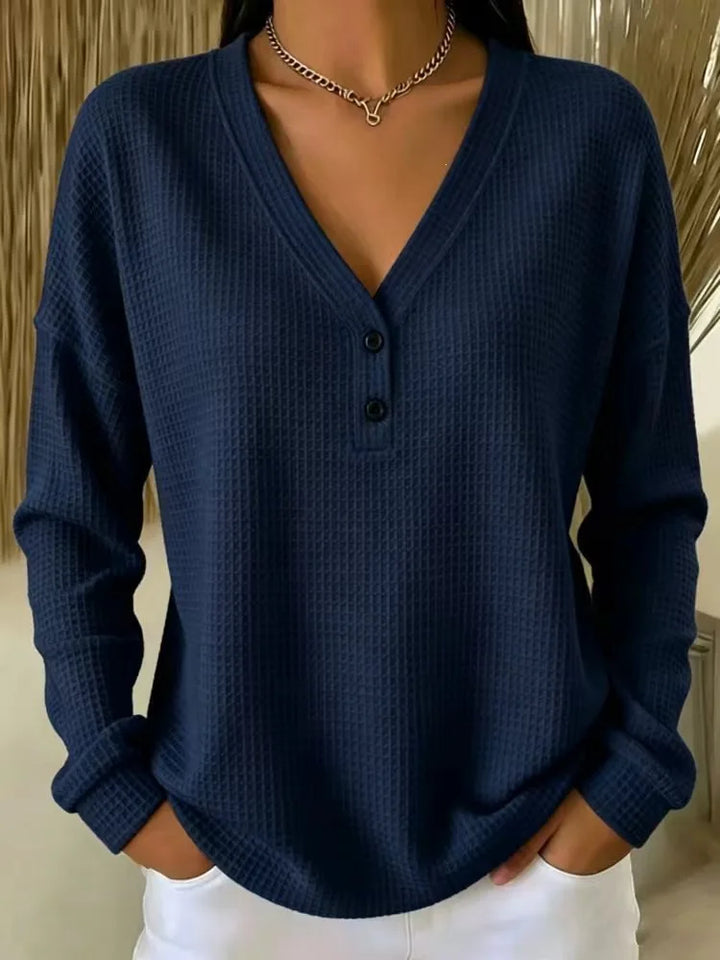 Woman wearing navy blue waffle knit V-neck henley top with button placket