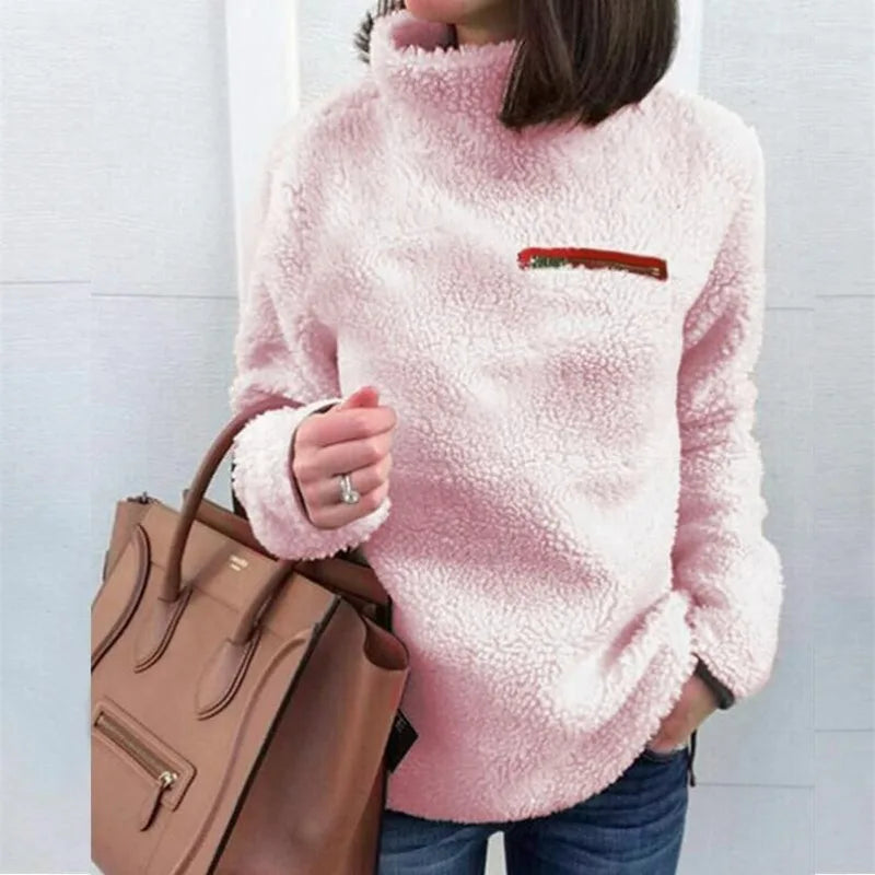 Woman wearing pink sherpa turtleneck pullover with zip chest pocket