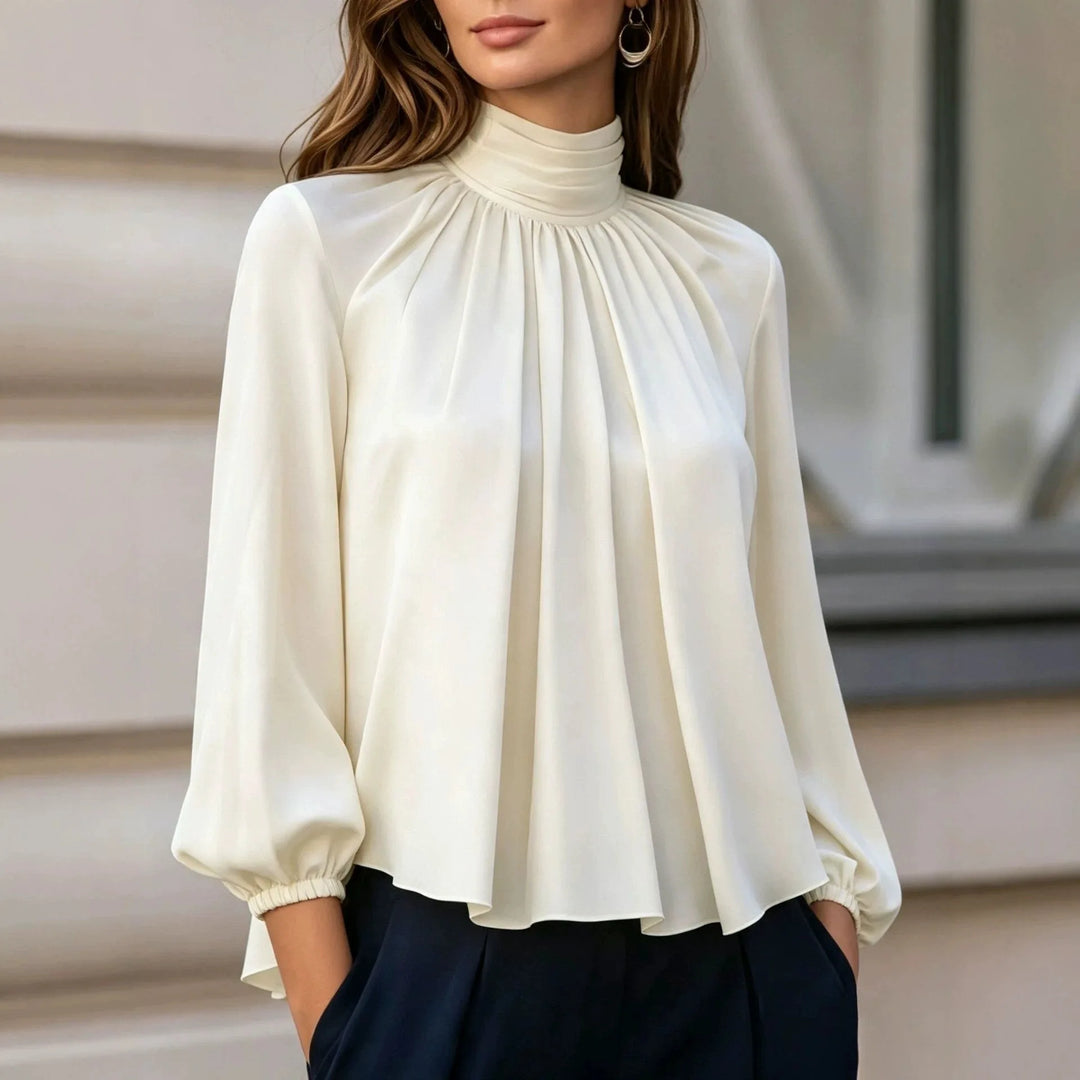 Woman wearing ivory pleated mock neck blouse with bishop sleeves