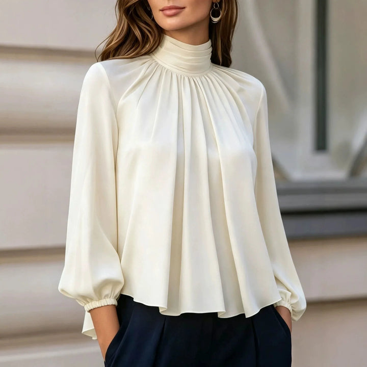 Woman wearing ivory pleated mock neck blouse with bishop sleeves