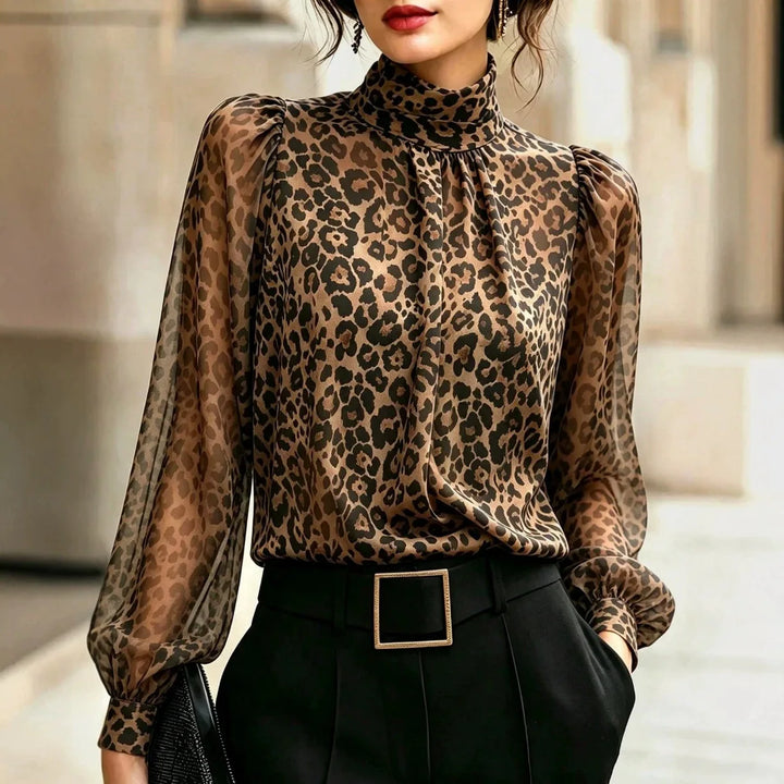 Woman wearing leopard print blouse with high mock neck and sheer lantern sleeves